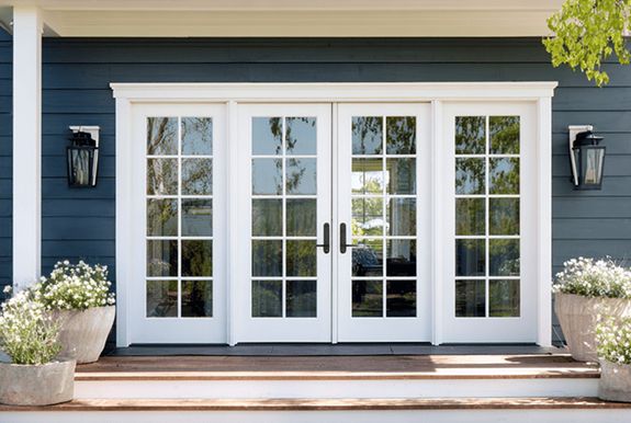 White French doors with glass panes set in a blue wall