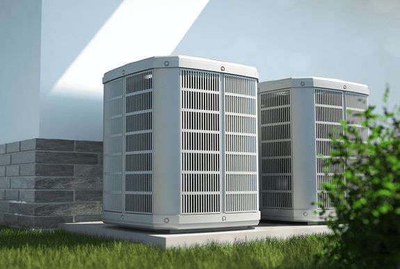 Two residential heat pump units installed outside a house