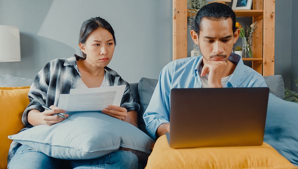 Couple reviewing flooring options on laptop and papers
