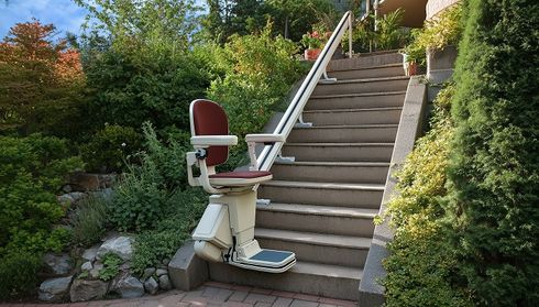 A stairlift is installed on an outdoor staircase