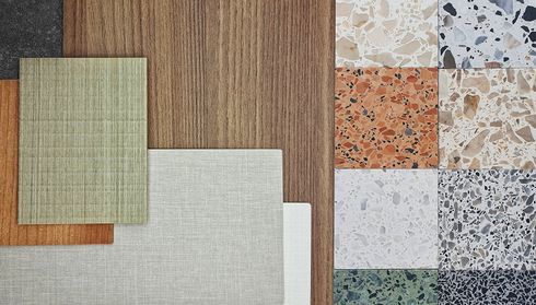 Assorted laminate and tile flooring samples on table