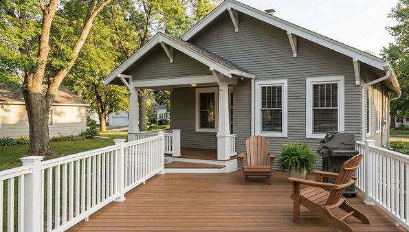 A charming gray house with a wooden deck