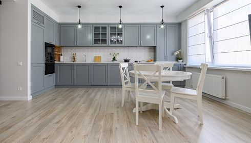 Kitchen and dining area with light wood-look laminate flooring