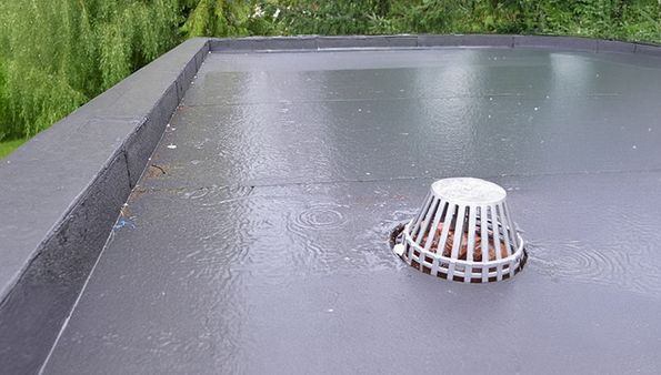 Flat roof with standing water around a roof drain