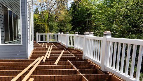 Unfinished wooden deck construction attached to a house