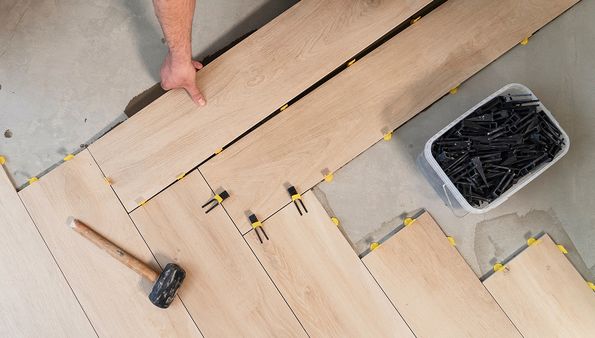 Luxury vinyl flooring installation with spacers and tools
