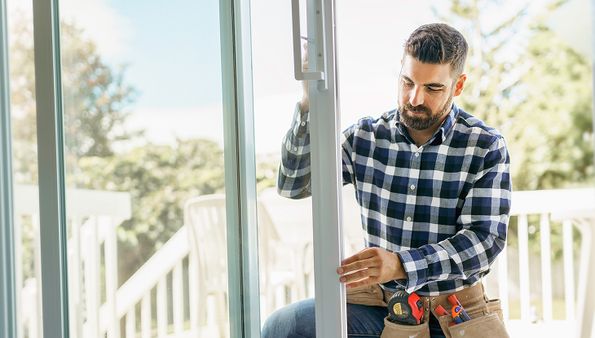 Installer adjusting a sliding patio door frame