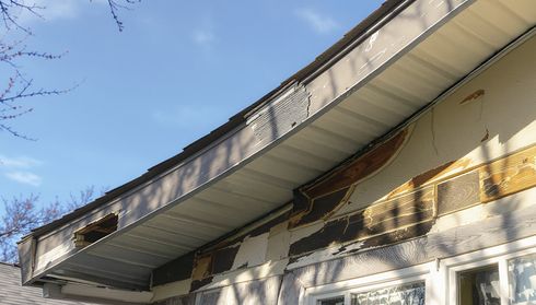 Damaged roof edge and exposed fascia before tear off and replacement